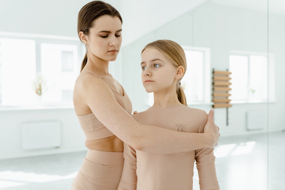 A ballet instructor assists a young student with posture during a dance class, emphasizing skill and grace.